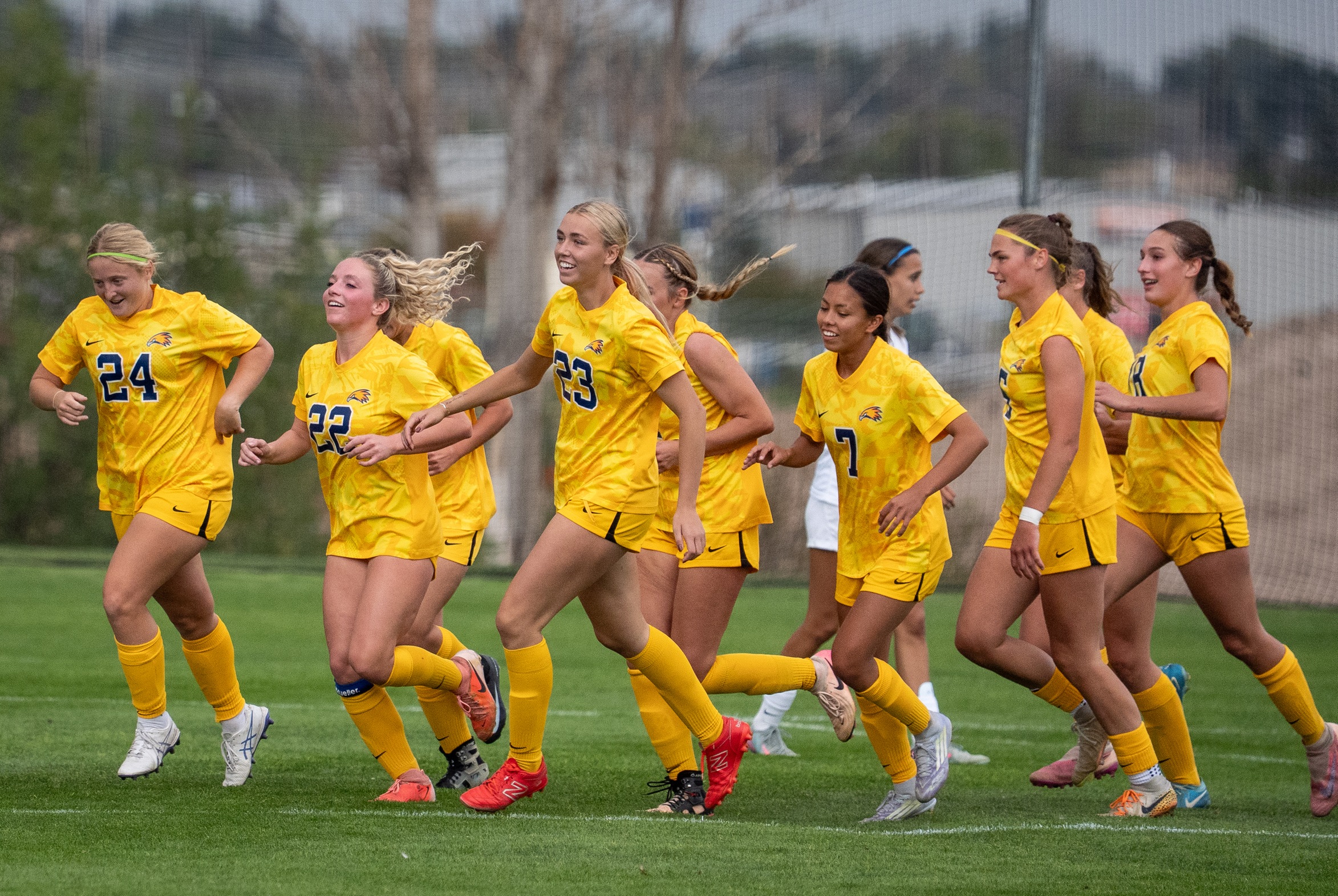 Golden Eagle group photo as they run to celebrate with their teammates after scoring a goal. 
